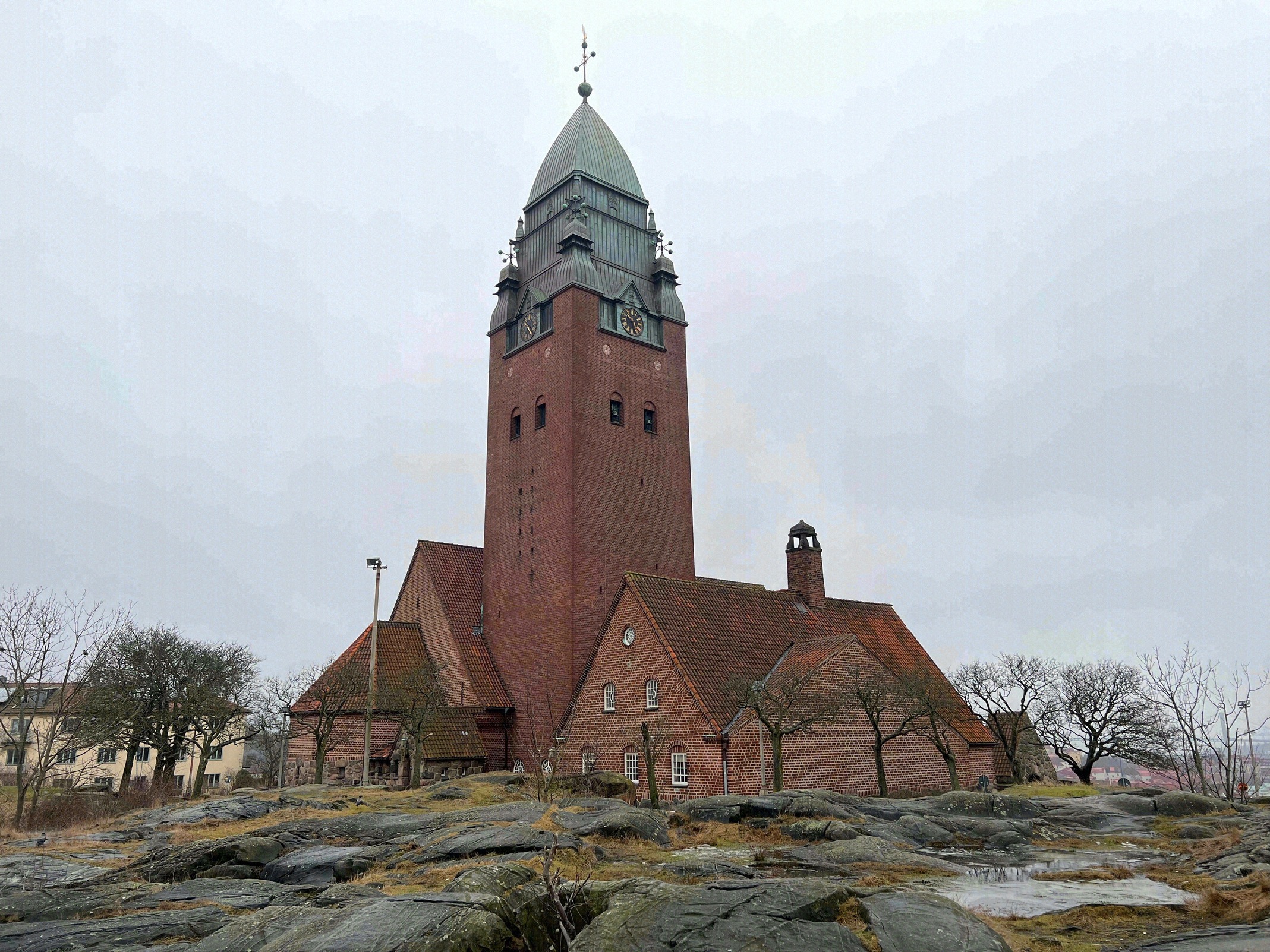 Die Masthuggskyrkan aus rotem Backstein mit ihrem markanten spitzen Kupferturm steht auf einem Granitfelsen hoch über dem Göteborger Hafen.